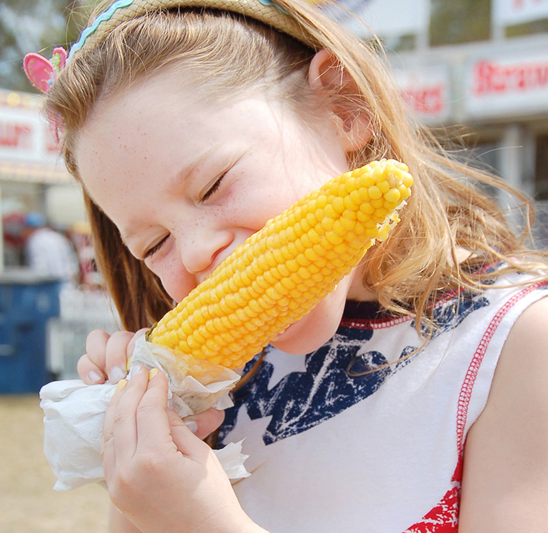 A girl eats corn on the cob