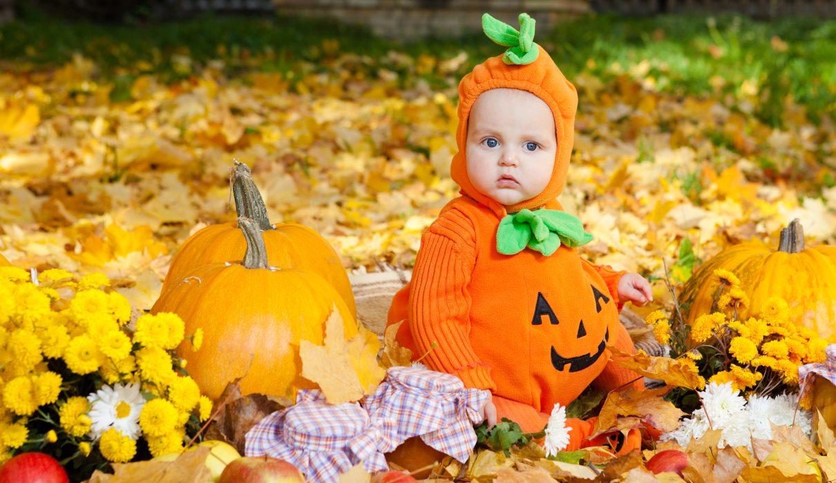 Child,In,Pumpkin,Suit,On,Background,Of,Autumn,Leaves