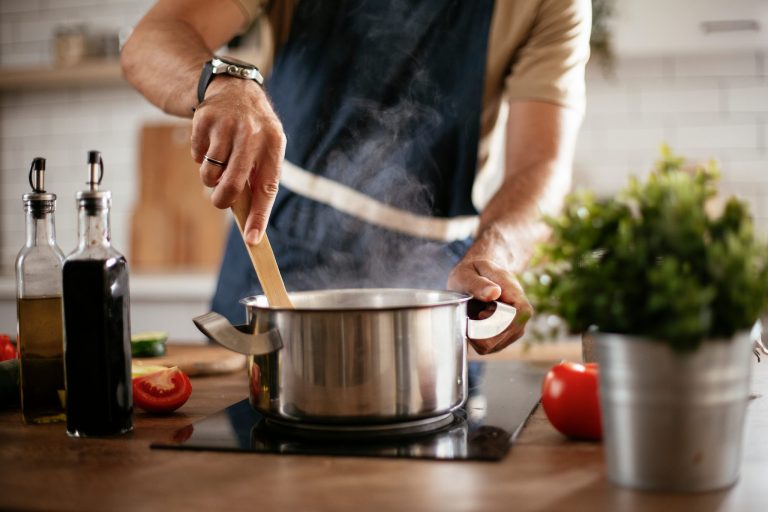 Young,Man,Cooking,Lunch,At,Home.,Handsome,Man,Preparing,Delicious