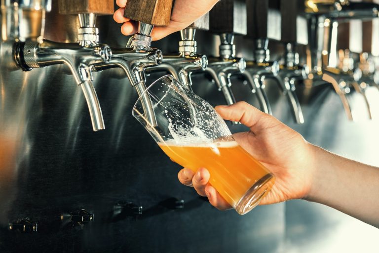 Hand,Of,Bartender,Pouring,A,Large,Lager,Beer,In,Tap.