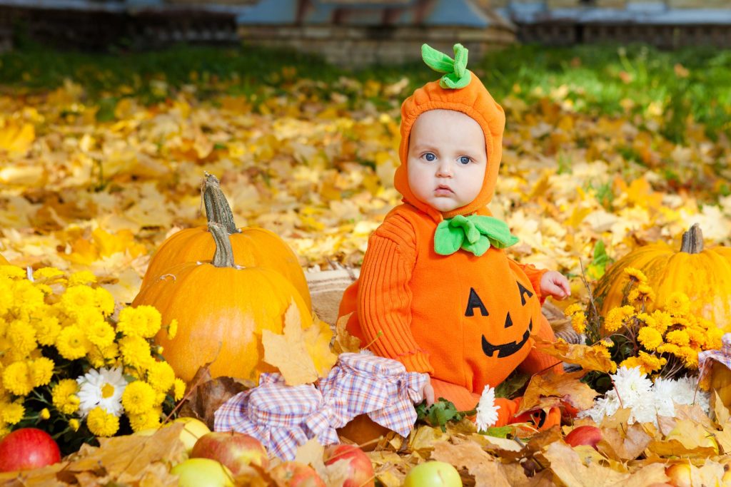 Child,In,Pumpkin,Suit,On,Background,Of,Autumn,Leaves