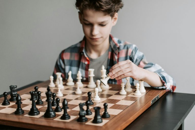 boy playing chess on table