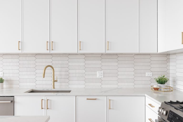 a,beautiful,kitchen,faucet,detail,with,white,cabinets,,a,gold