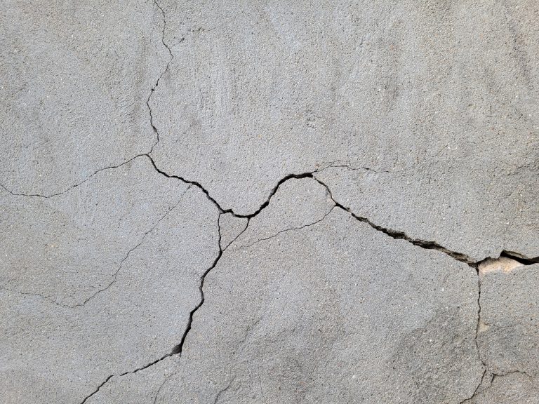 cracked,concrete,wall,covered,with,gray,cement,mortar.,destruction,caused
