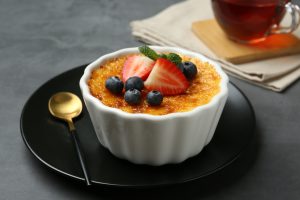 delicious,creme,brulee,with,berries,and,mint,in,bowl,on