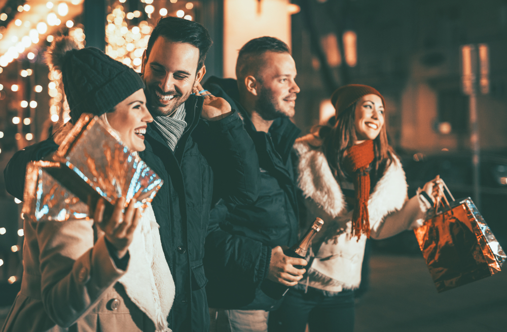 four,smiling,young,friends,standing,outside,and,holding,many,shopping