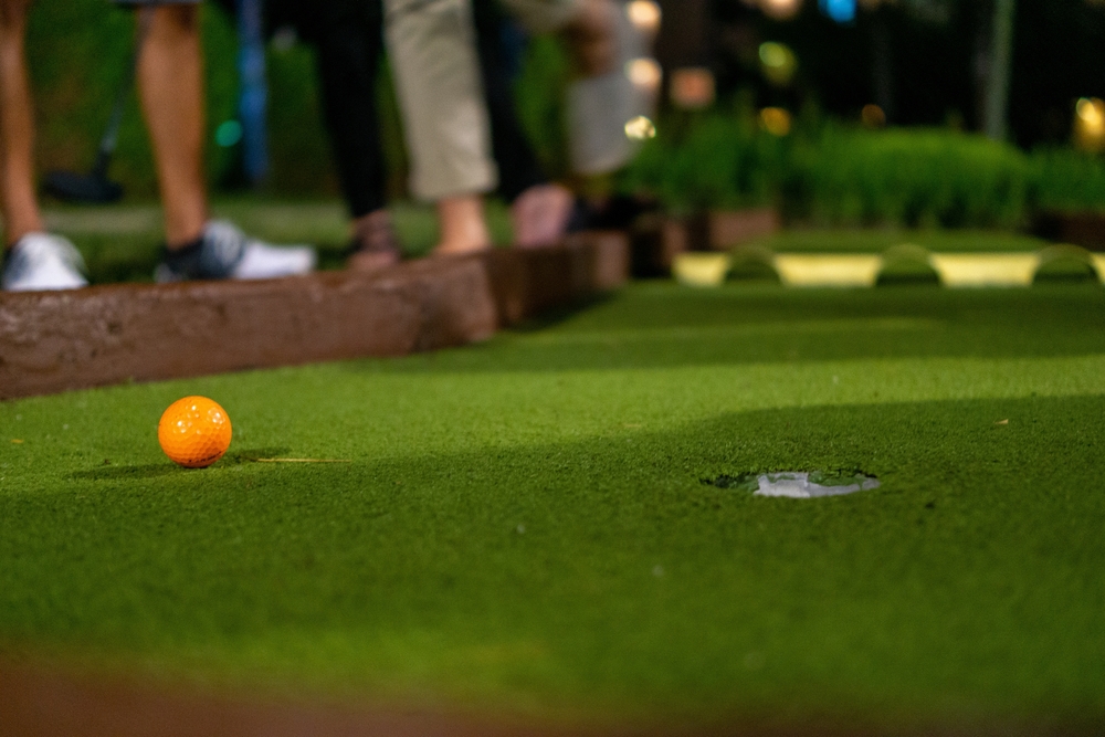 orange,golf,ball,on,a,mini,golf,course.,intentional,blur.