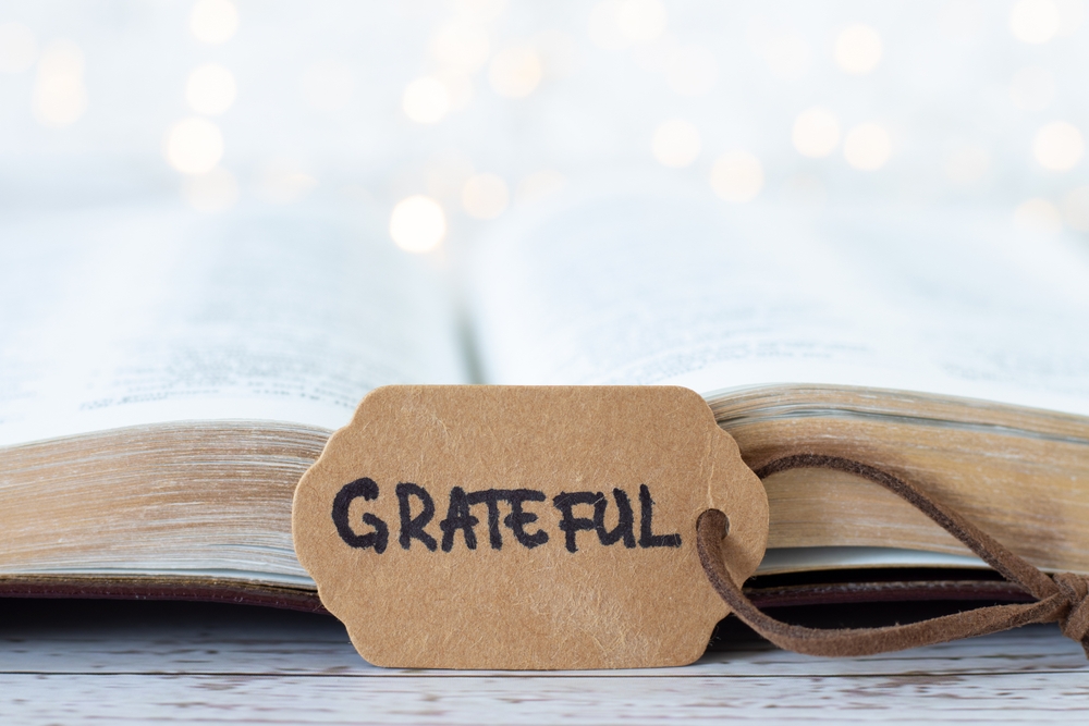 grateful,,handwritten,word,on,rustic,paper,with,open,holy,bible