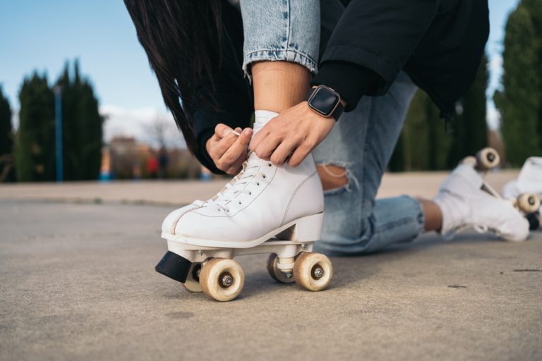 anonymous,hands,lace,quad,skate,on,an,urban,rink.,close up